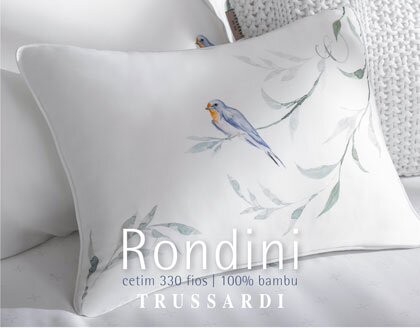 Inspirado nas andorinhas que cruzam os céus da Itália, Rondini é um jogo de cama em fibra de bambu com estampa delicada em tons aquarelados. Cada detalhe reflete a leveza e a elegância da vida italiana, trazendo a suavidade de Roma para o seu quarto. O toque do bambu envolve a pele de forma natural e confortável, enquanto as cores da estampa criam uma atmosfera de frescor e sofisticação. Rondini transforma o descanso em uma experiência de arte e bem-estar. O modelo entrega acabamento em ponto ajour na dobra feita do lençol de cima e nas 3 abas das fronhas. O tecido Bambu traz uma experiência única de maciez, conforto e frescor. Além disso, possui propriedades termorreguladoras, que ajudam a manter a temperatura do corpo equilibrada durante a noite. Devido a ser obtido a partir de uma planta que cresce rapidamente, seu ciclo de produção torna-se sustentável. Proporcione-se um maior bem-estar para uma noite de sono reparador com a linha Trussardi Bambu! 