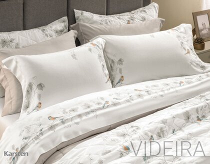 De toque supremo com experiência sensorial do cetim 300 fios, produzido com 100% algodão egípcio de fibras longas. Esse tecido sedoso, de toque extremamente macio e com cintilância natural, por conta do entrelaçamento dos fios; além disso, sua estrutura maleável proporciona um caimento perfeito na cama. O algodão egípcio tem propriedades hipoalergênicas e altamente respiráveis, que regulam a temperatura corporal e proporcionam uma noite de sono perfeita. Suas fibras longas impedem a formação de bolinhas e garantem fios mais finos, criando um tecido muito mais suave e confortável. O jogo de cama Videira nos transporta aos vinhedos, com uvas, parreiras, pássaros e paisagens inspiradoras. As fronhas 3 abas de 7cm com acabamento em ponto ajour recebem uma estampa dimensionada com ricos detalhes que emolduram os travesseiros, enquanto o sobre lençol apresenta uma vira dimensionada na cor branca e estampa de folhas e pássaros em tons de cinza, azul e laranja que enriquece a composição. O lençol com elástico traz uma estampa de linhas assimétricas em tons claros, que harmoniza com facilidade. Com caimento perfeito do cetim, Videira une a naturalidade do desenho feito à mão à sofisticação de um design único.